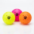 Three colorful perforated pickleballs in neon yellow, pink, and orange with 67 logo