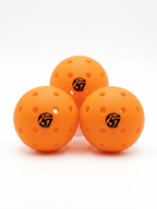 Three orange pickleballs with the 67 logo on a white background