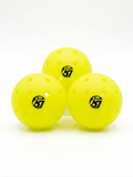 Three yellow perforated pickleballs with the number 67 logo on a white background