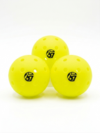 Three yellow perforated pickleballs with the number 67 logo on a white background
