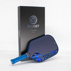 TOCO67 blue carbon fiber pickleball paddle and its black branded packaging box